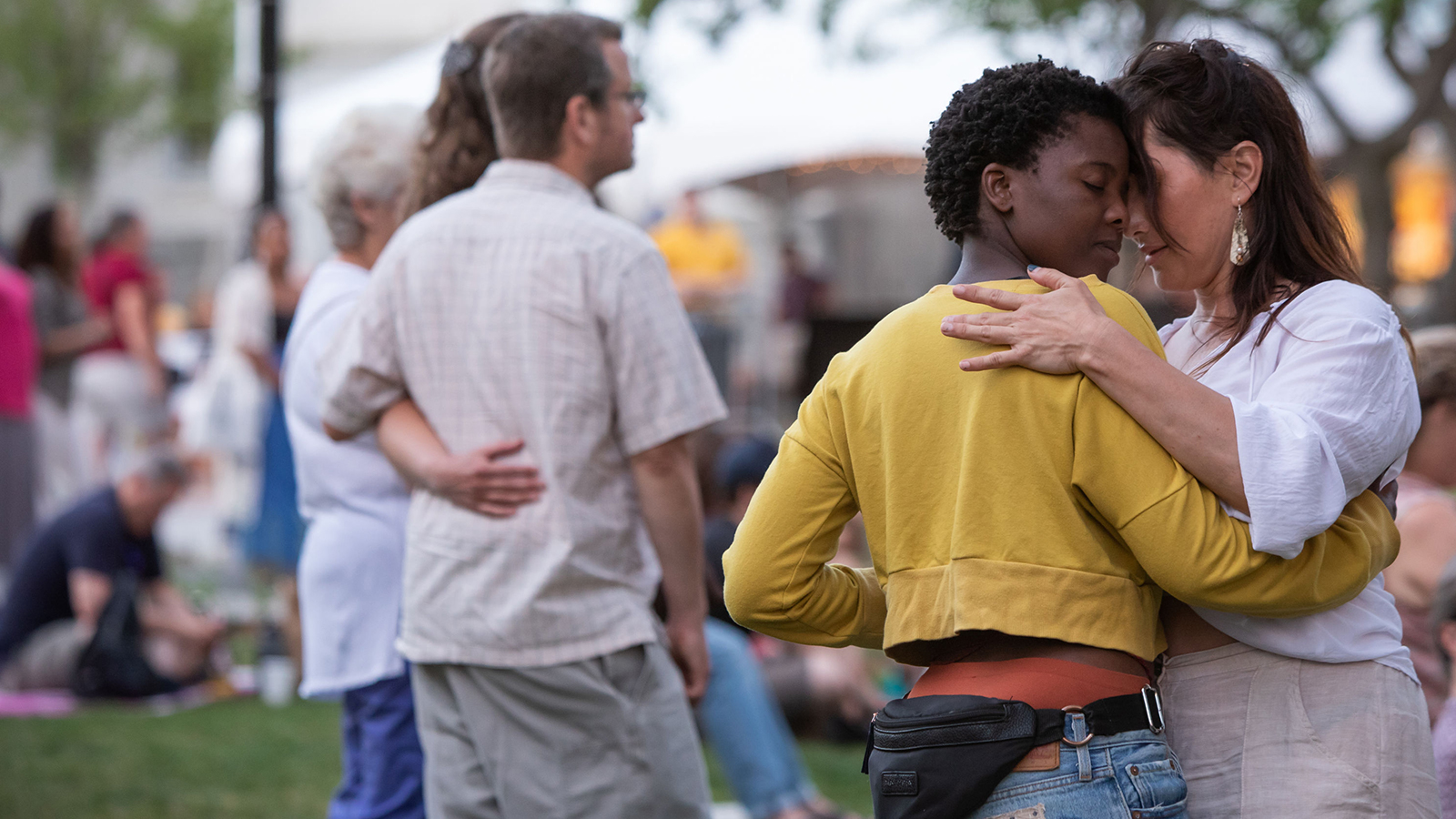 Two couples watch and dance at a concert in City Hall Park.