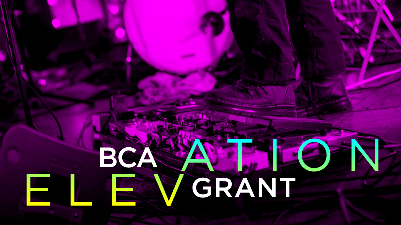 BCA Elevation Grant in yellow and blue ombréd text over an image of a person's feet, wearing dark oxford shoes, stepping on a guitar pedal with drums visible in the background and a purple filter over the image