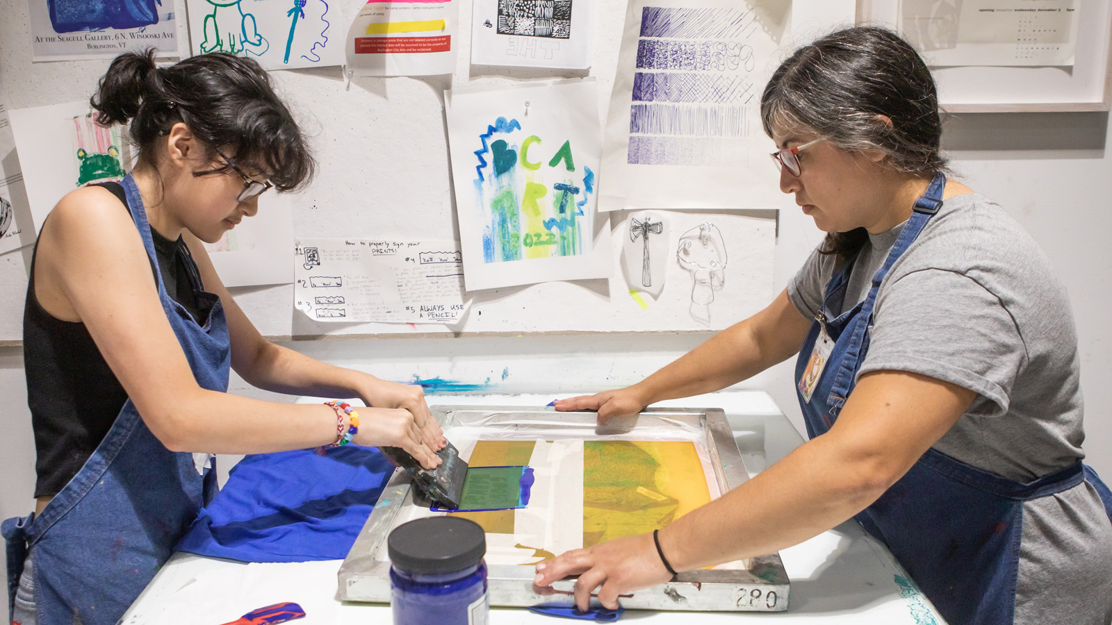 A youth getting instruction from a screen print instructor