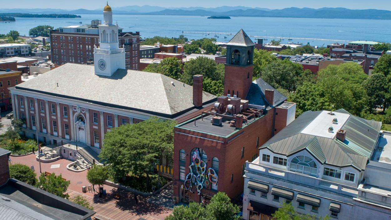 An aerial photograph of the BCA Centter with a colorful installation on the facade