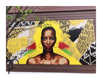 Mural of black woman with yellow background and text from the emancipation proclamation
