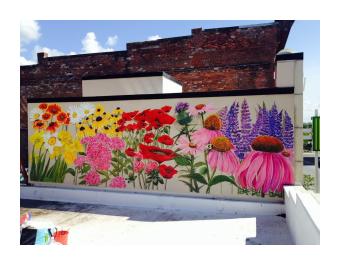 a mural of oversize flowers with pink echinacea, purple lupines, red poppies, yellow black eyed susans, and orange zinnias