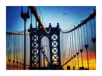 A photograph of the brooklyn bridge at night up close with a twilight sky behind