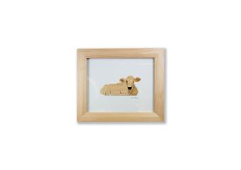 the use of wood to create an image of the side view of a cow sitting down.