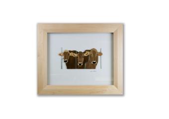 An image of a front view of three cows made out of wood within a wood shadow box