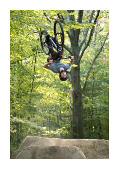 Photography of a biker doing a flip midair.