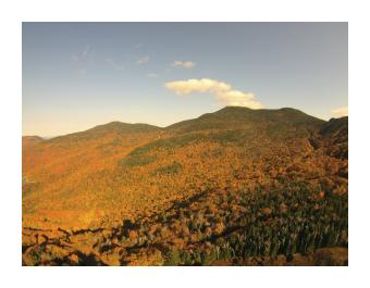 Photograph of a mountain bathed in the orange light of the sunset.