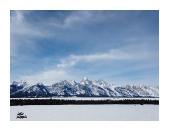 Photograph of a snowy mountain across a snow-covered plain, white and blue.