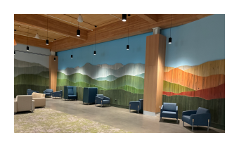 a photo of an at installation Vert Mont by Ben Butler that is comprised of painted reclaimed boards that are assembled to depict the green mountains 