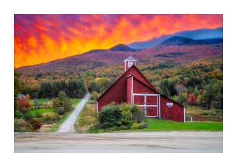 Photograph of a vibrant sunset in purples and oranges on a red barn. 