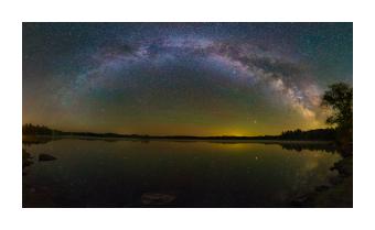 Photograph depicting the moxie milky way from a lake's perspective. 