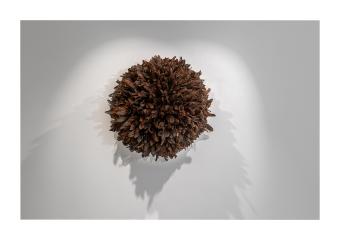 mixed media depicting a textured, brown moon, the texture made out to resemble feathers.