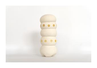 Limestone sculpture of five rounded ovals with three yellow dots on oval 3 and 4