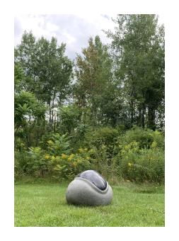 Sculpture of granite surrounding an embedded piece of polished granite. 