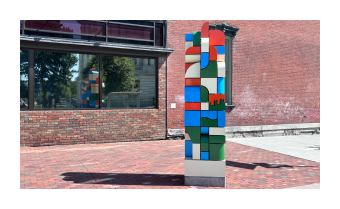 a photograph of Block by Block, a sculpture composed of multicolored blocks in a tower form 