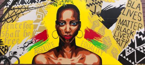 Mural of black woman with yellow background and text from the emancipation proclamation