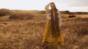 Ana May standing in a field at sunset