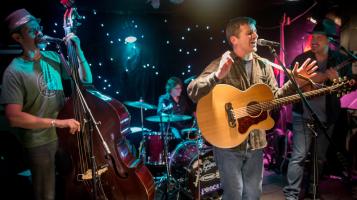 The members of The Brevity Thing on stage performing.