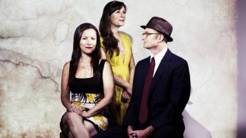 The three members of Low Lily sit, facing in different directions.