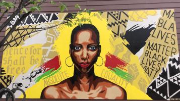 Mural of black woman with yellow background and text from the emancipation proclamation