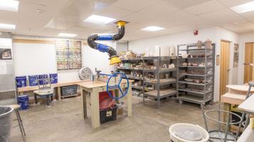The clay studio at BCA studios, with rolling racks of ceramics and pottery wheels
