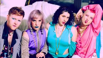 The band members of slut magic sitting on a sofa.