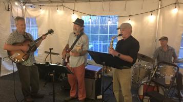 the quartet playing a gig in an outside tent.