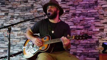 Jacob playing a steel guitar on stage
