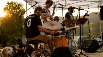 Moose Crossing playing on a small stage at sunset