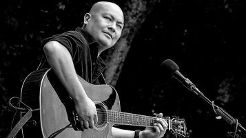 Steve is playing an acoustic guitar on stage