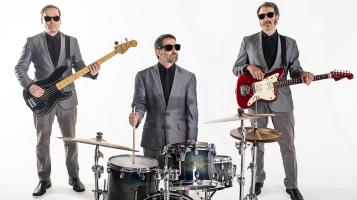 The Band with instruments wearing gray suits and black sunglasses