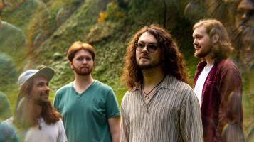 four band members in a refracted blurry image of them in a field