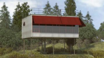 A photograph of a small, white modern building, a rectangle raised above the ground on thin metal legs, with one side of windows with a maroon awning above. Evergreen trees and a blue sky dotted with clouds in the background.