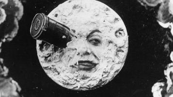An image from Trip to the Moon, featuring a rocket ship projecting from the eye of the moon's face.