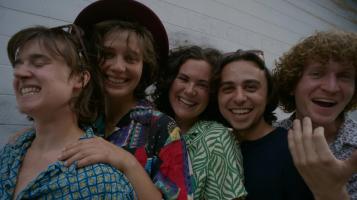 Five people smile, looking at the camera