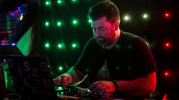 dj with neon lights behind him