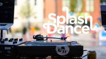 A tight crop of a deejay setup infront of an outdoor splash fountan