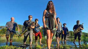 The band holding their instruments standing in swamp land on a beautiful blue sky summer day