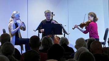 three people playing music with a crowd