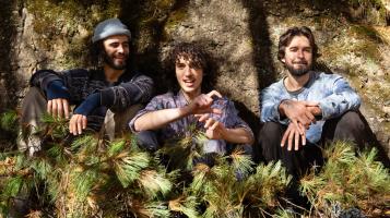 three guys sitting outside.