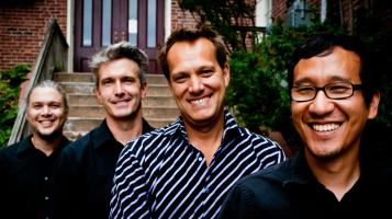 Members of Trio Gusto pose together in front of a residence