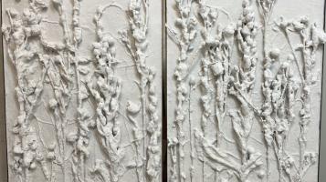 Sculpture work in white plaster depicting a field of foliage.