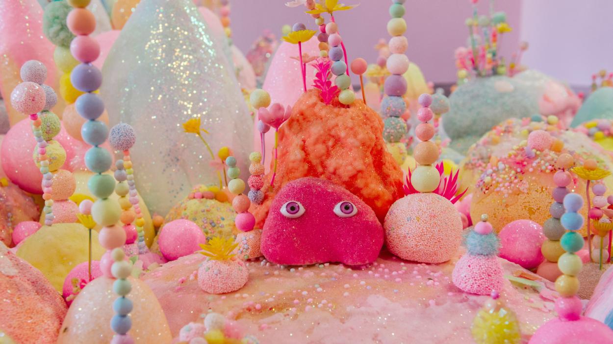 A playful blobby creature surrounded by colorful mounds