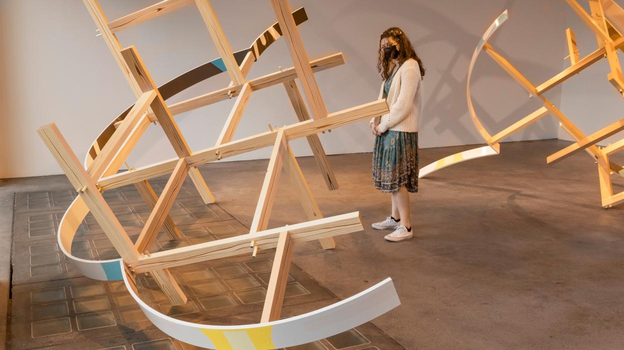 A person views Kirsten Reynold's 3-D geometric sculture