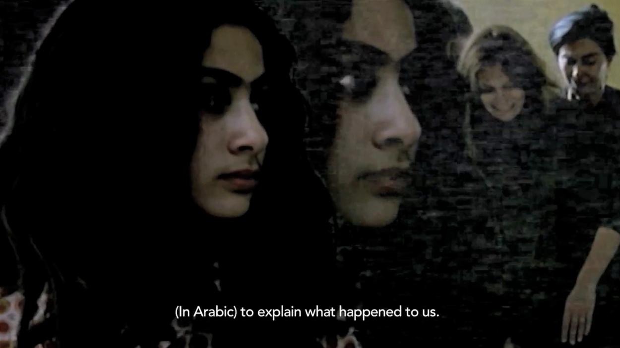 A still from Sarah Trad's video, Clench my Fist, showing two overlapping close ups of the face of a woman with dark hair, brown eyes and olive skin, with glitchy images of two different women laughing in the background