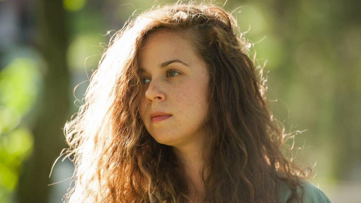 6950a70f-9878-4b68-8966-256ff5104b67.jpeg A headshot of a light skinned woman with dark red hair