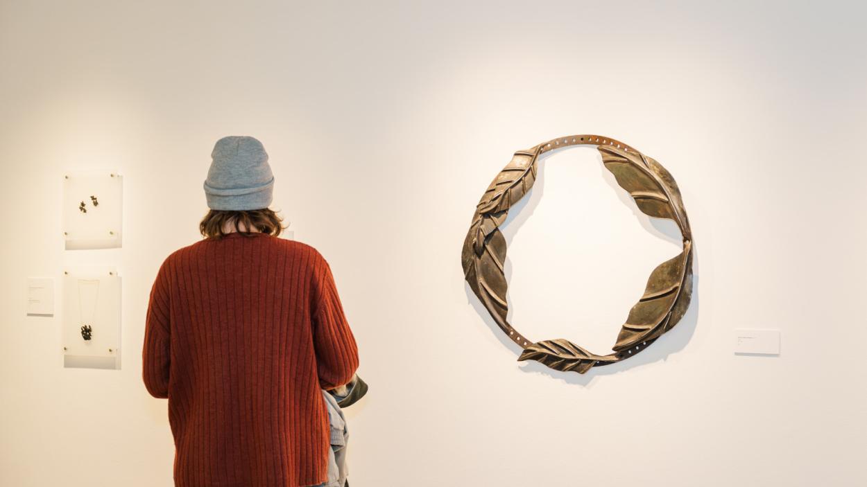 A woman standing with her back to the camera observing the Margaret Jacobs exhibition
