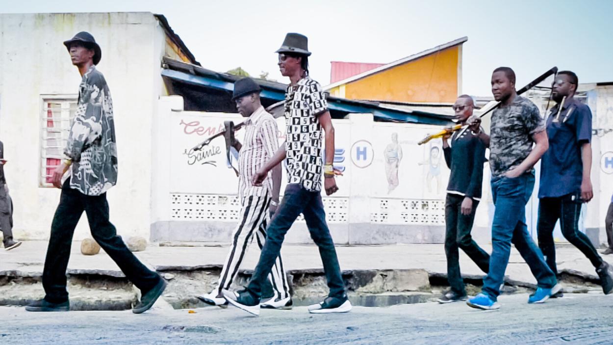 a band walks down a street against the backdrop of a building