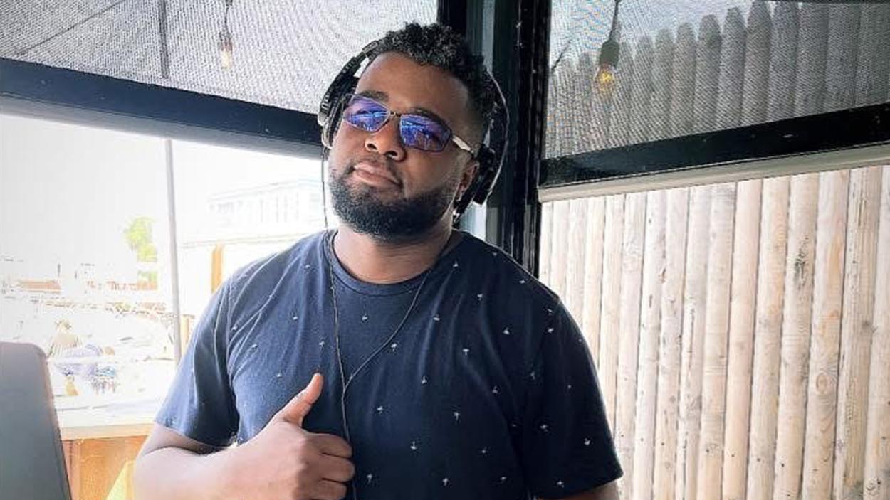 person standing with thumbs up and shades on