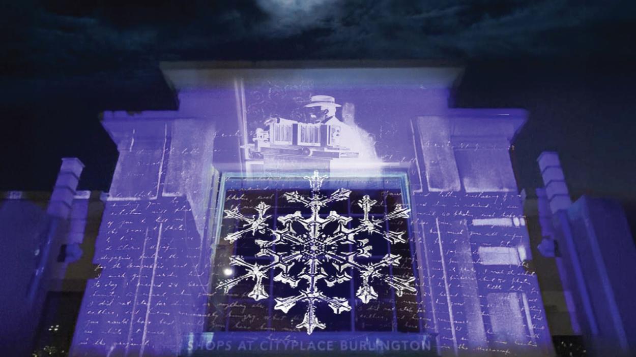 A photo of the former City Place Mall all lit up with blue hues of light.